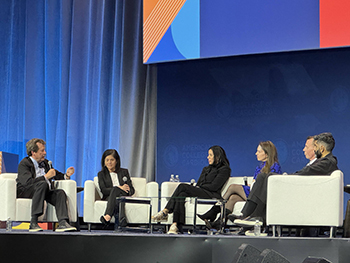 Robert Califf speaks into a microphone while participating in a panel discussion at ACC25.