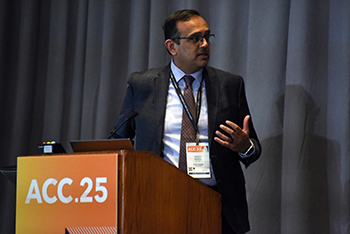 Manesh Patel stands at a podium and turns to speak to fellow panelists following a presentation at ACC25.
