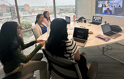 Students in the STAR program discuss their project with virtual members of their team in a conference room overlooking the city of Durham.