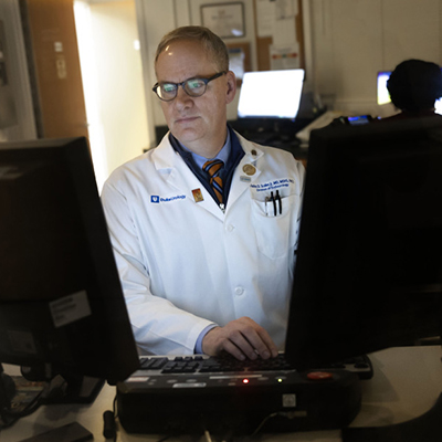 DCRI faculty member Chuck Scales sits at a computer analyzing study data.