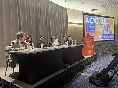 Rob Califf is seen in the foreground sitting on a panel at ACC.26.
