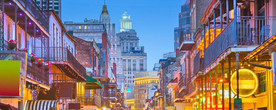 A colorful evening view of a street in New Orleans' French Quarter.